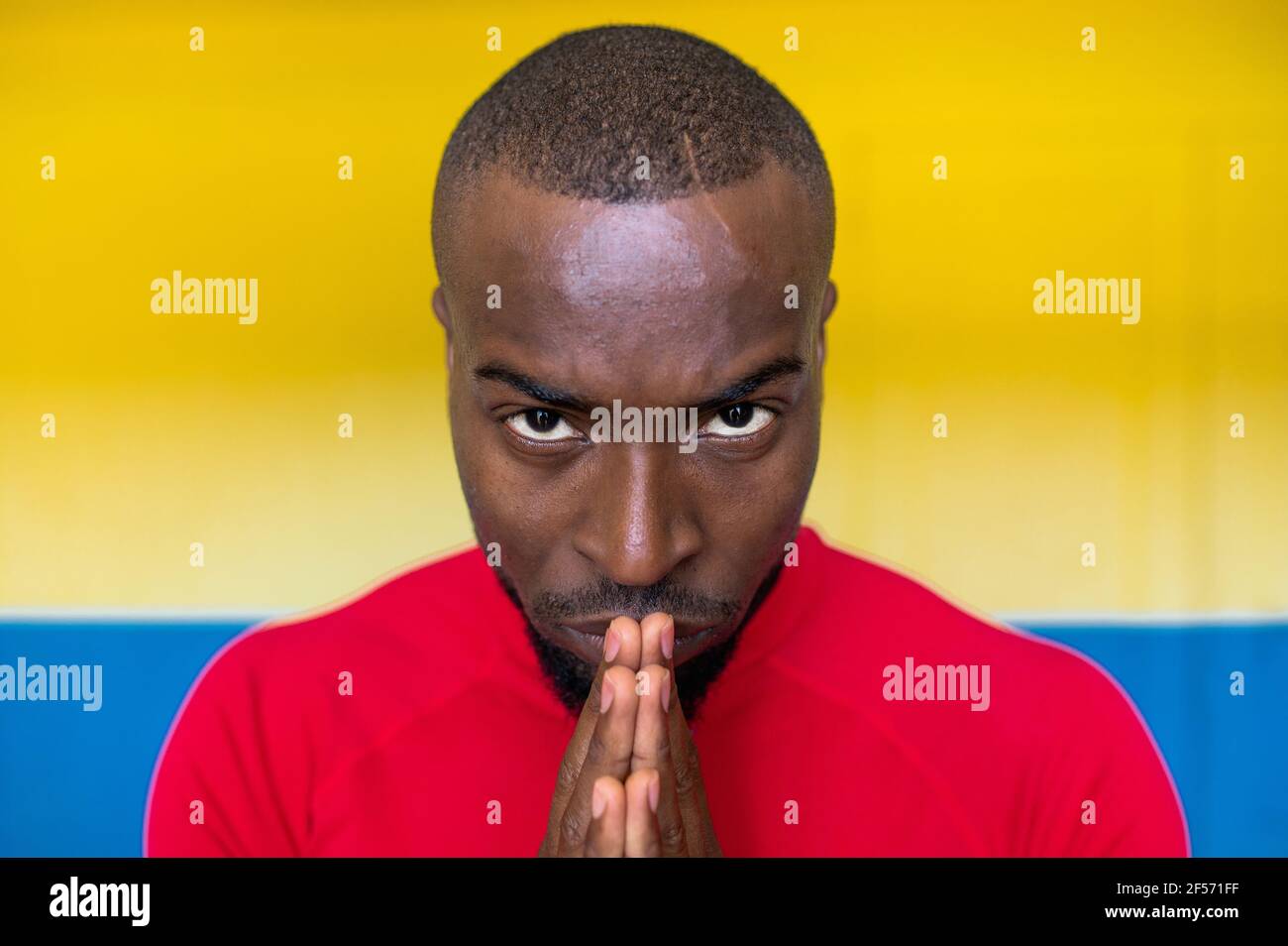 Nahaufnahme des schwarzen afrikanischen Menschen konzentriert und fokussiert aussehen mit Zusammengeschlossen Hände Vorbereitung für einen Wettbewerb und Blick nach vorne Stockfoto