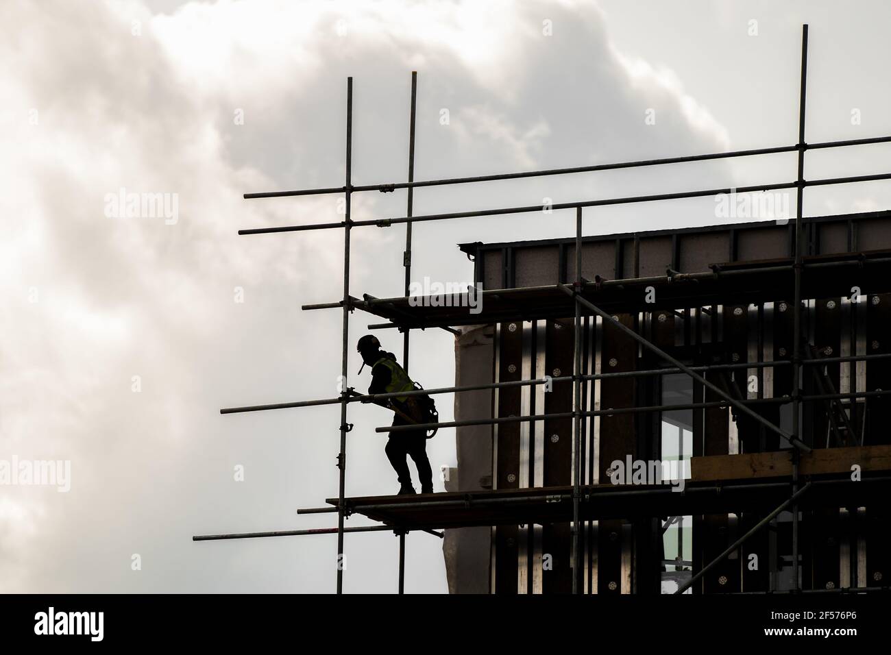Silhouette Gerüst in PPE Errichtung Rahmen aus Holzplanken und hohen Gerüstmasten hoch oben auf moderne Neubau Baustelle. Suchen Stockfoto