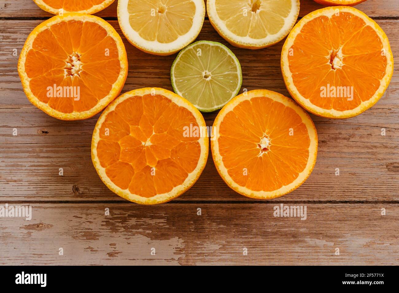 Orangen, Limetten und Zitronen Rutschen auf Holztisch Blick von oben. Wunderschön Hintergrund mit frischem Obst halb geschnitten.gesunde Ernährung Vitamin C.Sommer tropic Stockfoto