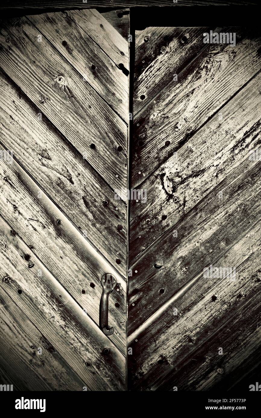 Alte verwitterte Holztüren mit Brettern im V-Muster Stockfoto