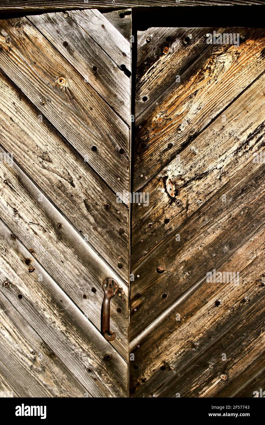 Alte verwitterte Holztüren mit Brettern im V-Muster Stockfoto