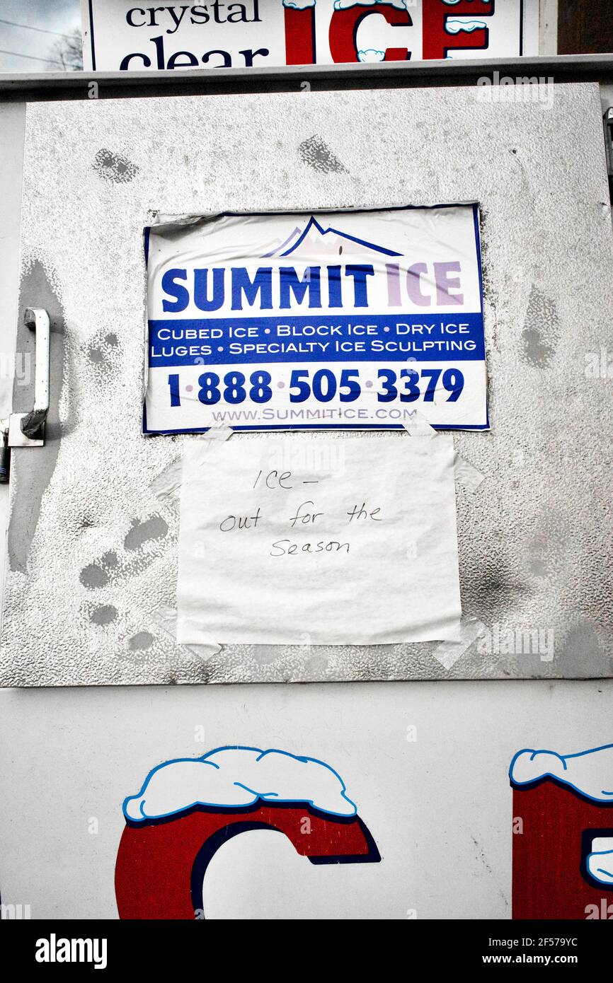 Nahaufnahme der Eisbox am Rastplatz. Schild mit der Marke Summit Ice an der Tür. Handgeschriebenes Schild mit „Ice out for the season“ an der Tür. Stockfoto