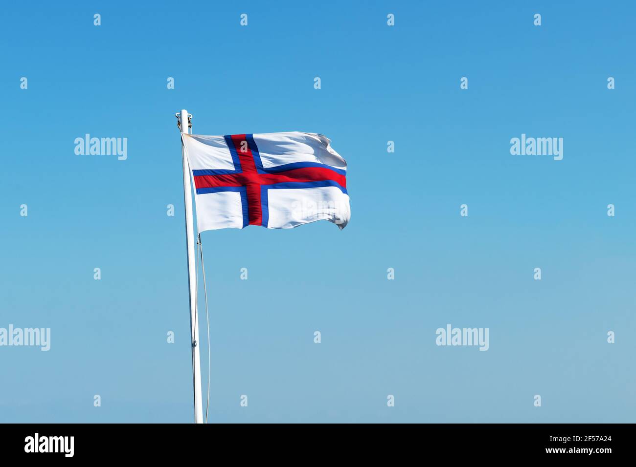 Flagge der Färöer Inseln auf blauem Himmel Hintergrund Stockfoto