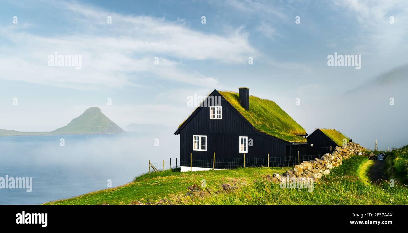 Neblige Morgenansicht eines Hauses mit typischem Grasdach Stockfoto