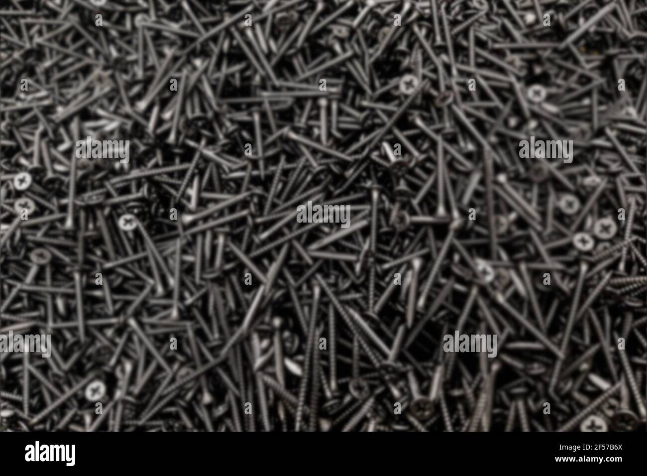 Selbstschneidende Schraube Black Steel Lot Stapel Bau Shop Hintergrund Verschwommen. Stockfoto