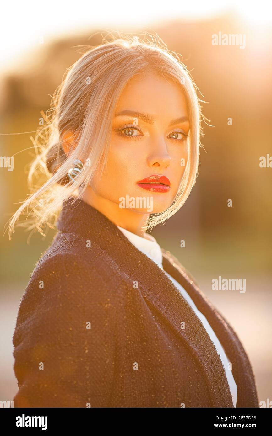 Schöne stilvolle Dame Blick auf Kamera im Freien Stockfoto