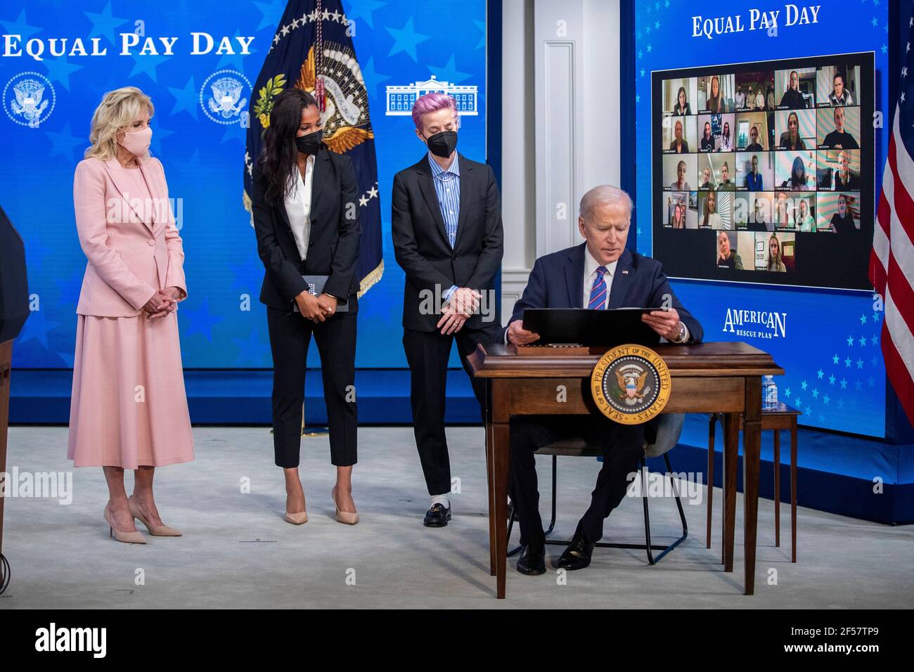 US-Präsident Joe Biden, mit First Lady Dr. Jill Biden (L), Margaret Purce (2-L), Megan Rapinoe (2-R) und anderen Mitgliedern der US Soccer WomenÕs National Team, unterzeichnet eine Proklamation während einer Veranstaltung zum Tag der gleichen Bezahlung im Staatlichen Speisesaal des Weißen Hauses in Washington, DC, USA, 24. März 2021. Equal Pay Day markiert die zusätzliche Zeit, die es dauert eine durchschnittliche Frau in den Vereinigten Staaten, um den gleichen Lohn zu verdienen, dass ihre männlichen Kollegen im vorherigen Kalenderjahr. Stockfoto