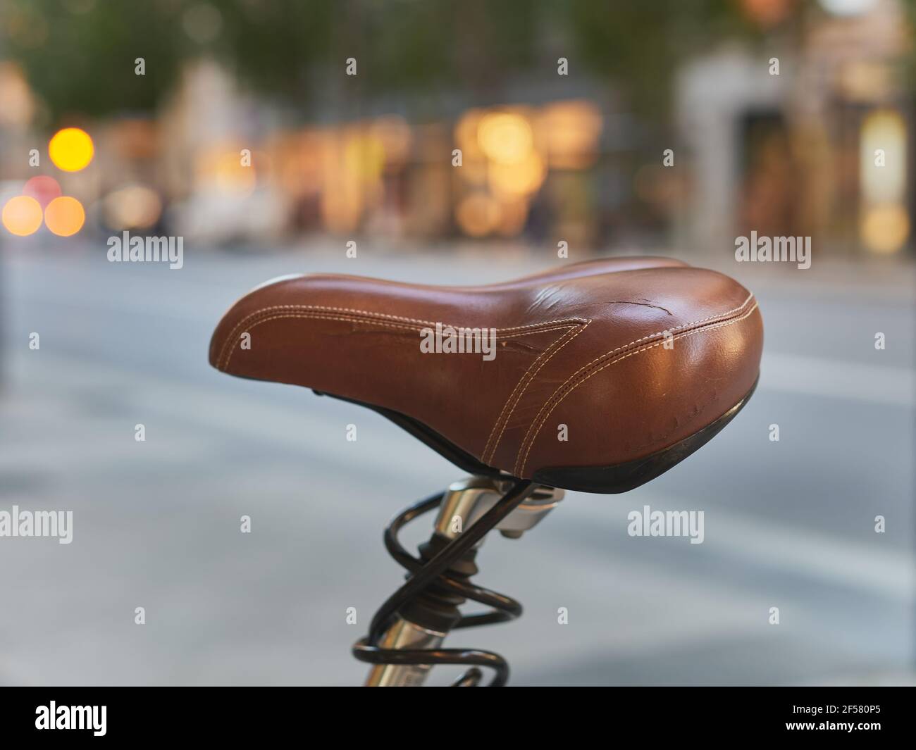 Detail eines abgenutzten braunen Ledersitzes eines Fahrrads An einer öffentlichen Straße Stockfoto