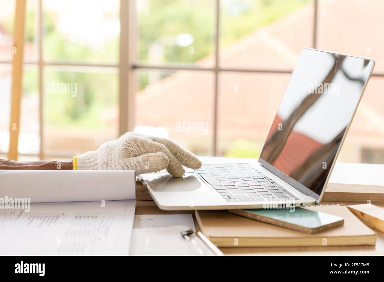 Der ältere oder ältere beginnt seine neue Karriere als Zimmermann. Lernen und suchen Sie Informationen online mit Computern. Stockfoto