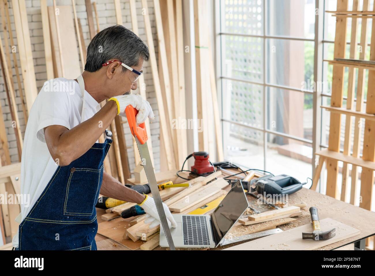 Der ältere oder ältere lernen neue Fähigkeiten, Lernen Sie ein Schreiner von Computern online zu werden. Stockfoto