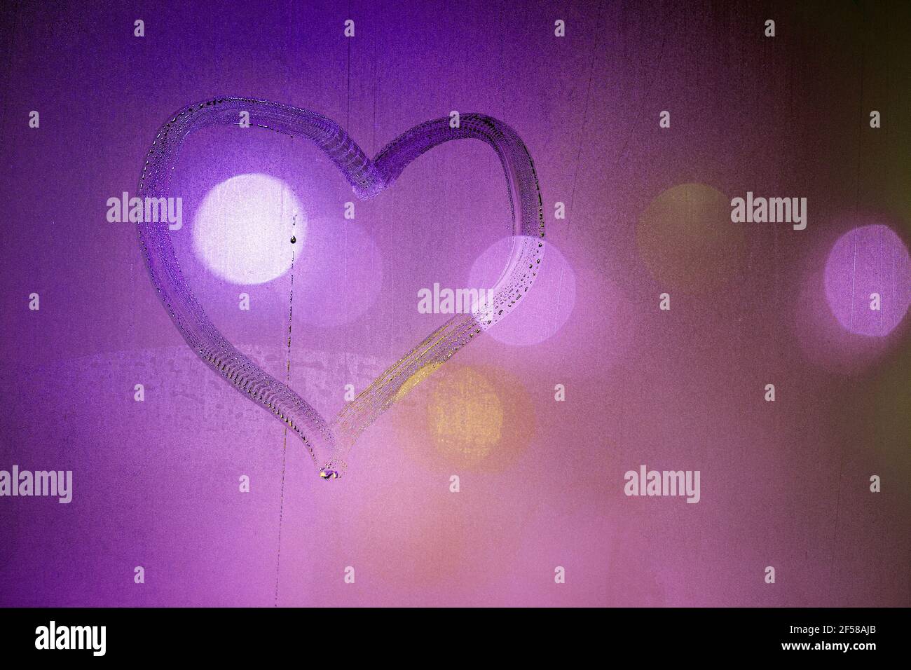 Herz Symbol von Hand auf nassem Nachtfenster Glas in rosa Farben gezeichnet. Stockfoto