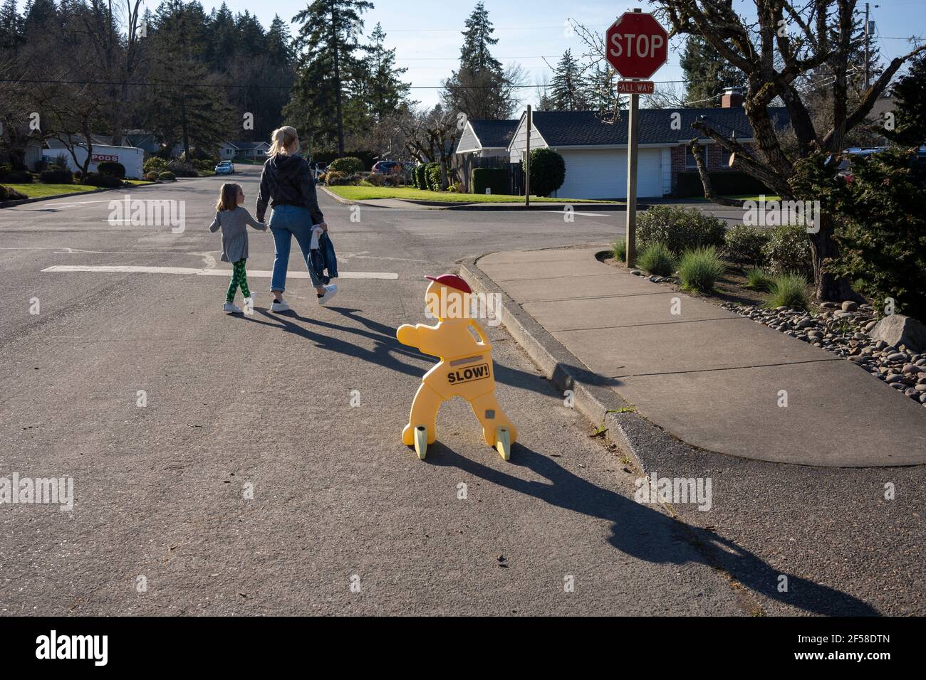 Ein maskierter Elternteil holt ihr Kind am Donnerstag, den 11. März 2021, von der Schule in Lake Oswego, Oregon, ab. Öffentliche Schulen in Oregon öffnen sich Anfang ... Stockfoto