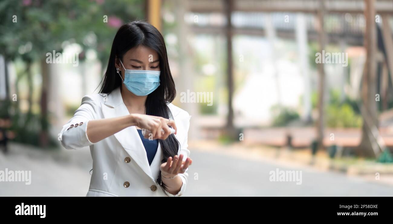 Porträt einer Geschäftsfrau, die Maske trägt und die Hände im Büro nach der Pandemie desinfiziert, Platz zum Kopieren. Stockfoto