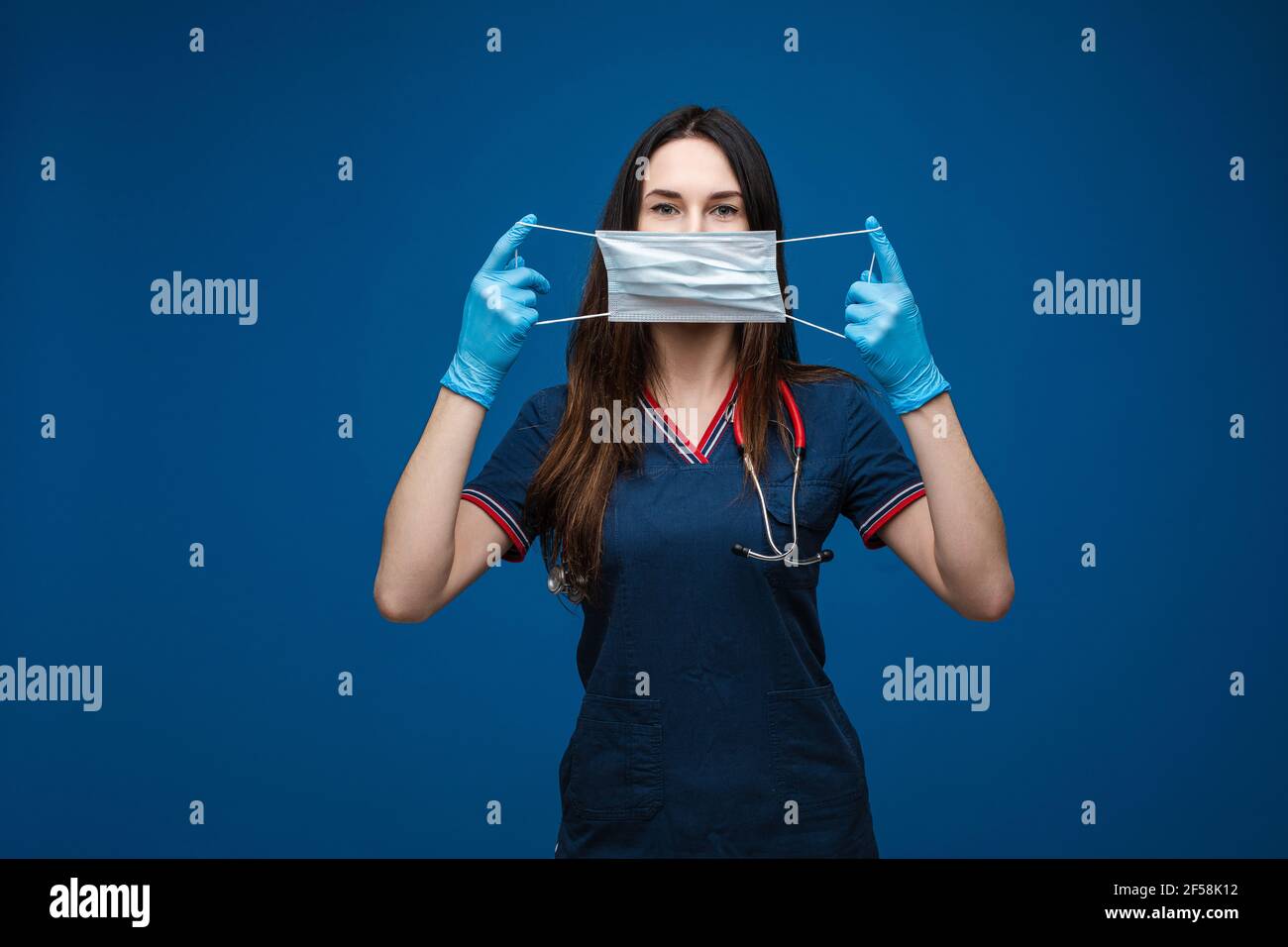 Doktor mit aseptischer Maske in den Händen vor ihrem Gesicht. Stockfoto