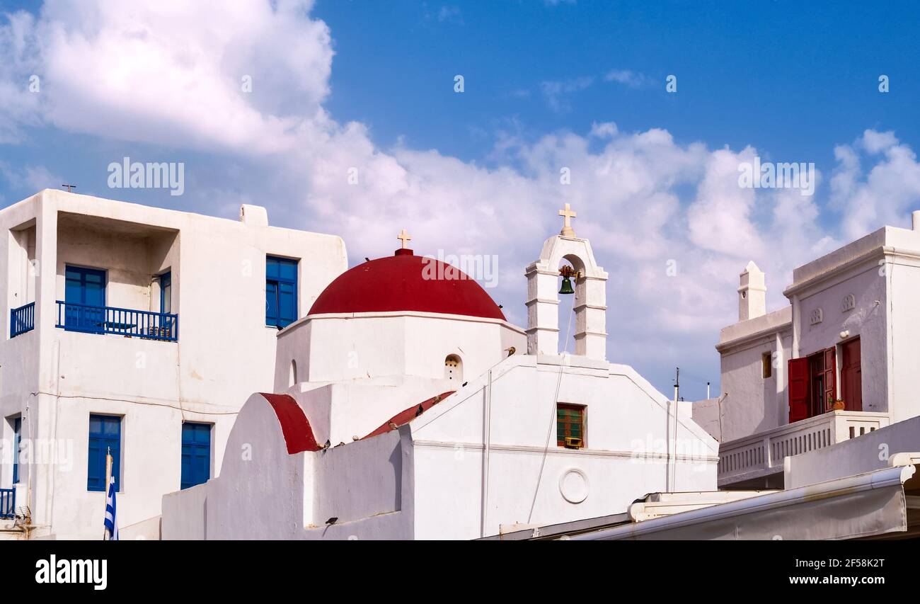 Traditionelle griechisch-orthodoxe Kirche in griechischer Inselstadt. Rote Kuppel, weiß getünchte Wände und Glockenturm. Mykonos, Kykladen, Griechenland. Stockfoto