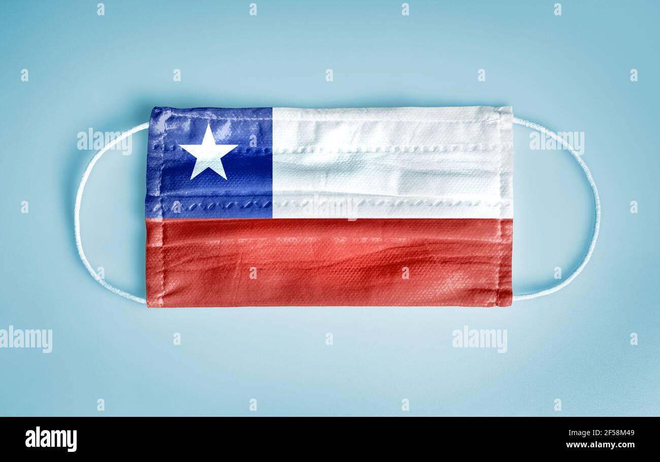 Covid-19 Coronavirus Schutzkonzept: Medizinische Einweg-Gesichtsmaske mit Chile-Flagge auf blauem Hintergrund. DIE WHO empfiehlt die Verwendung der Maske aus Sicherheitsgründen. Stockfoto