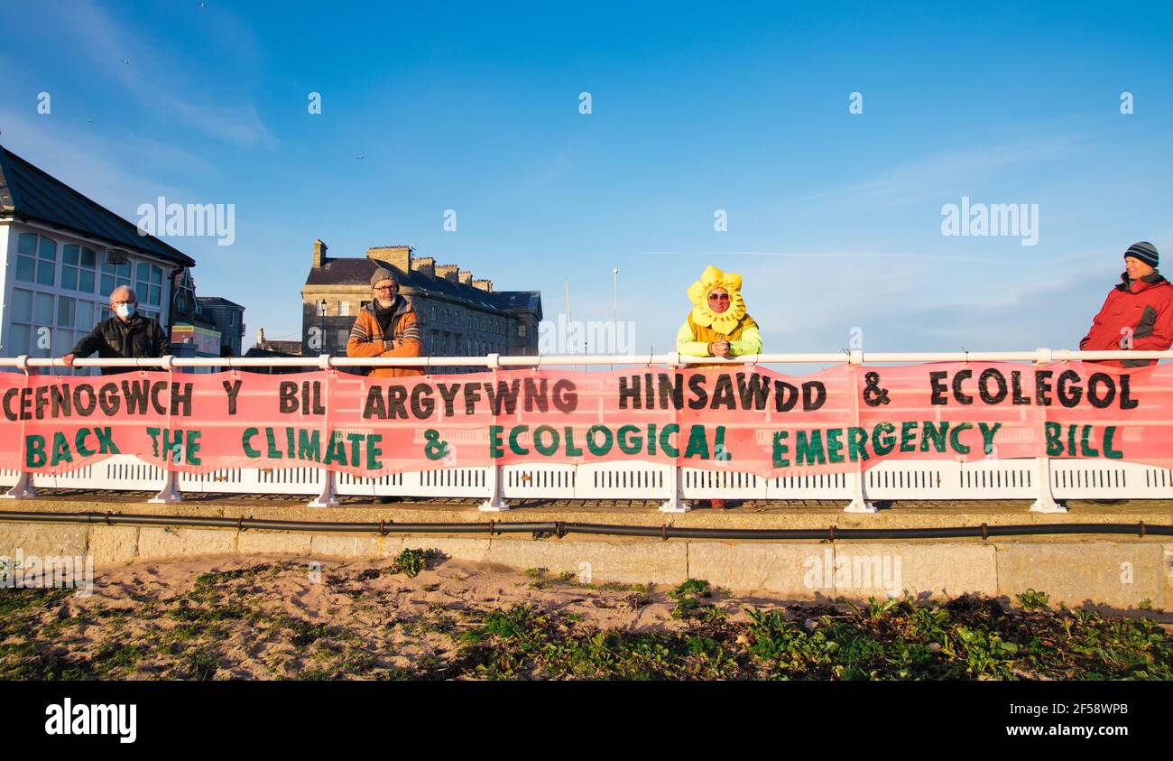 Beaumaris, Anglesey, Nordwales, Großbritannien. 24th. März 2021. Mitglieder der Extinction Rebellion North Wales hängen ein Banner, das die Unterstützung des Klima- und ökologischen Nothilfegesetzes fordert und die lokale Abgeordnete Virginia Crosby auffordert, den Gesetzentwurf zu unterstützen. Stockfoto