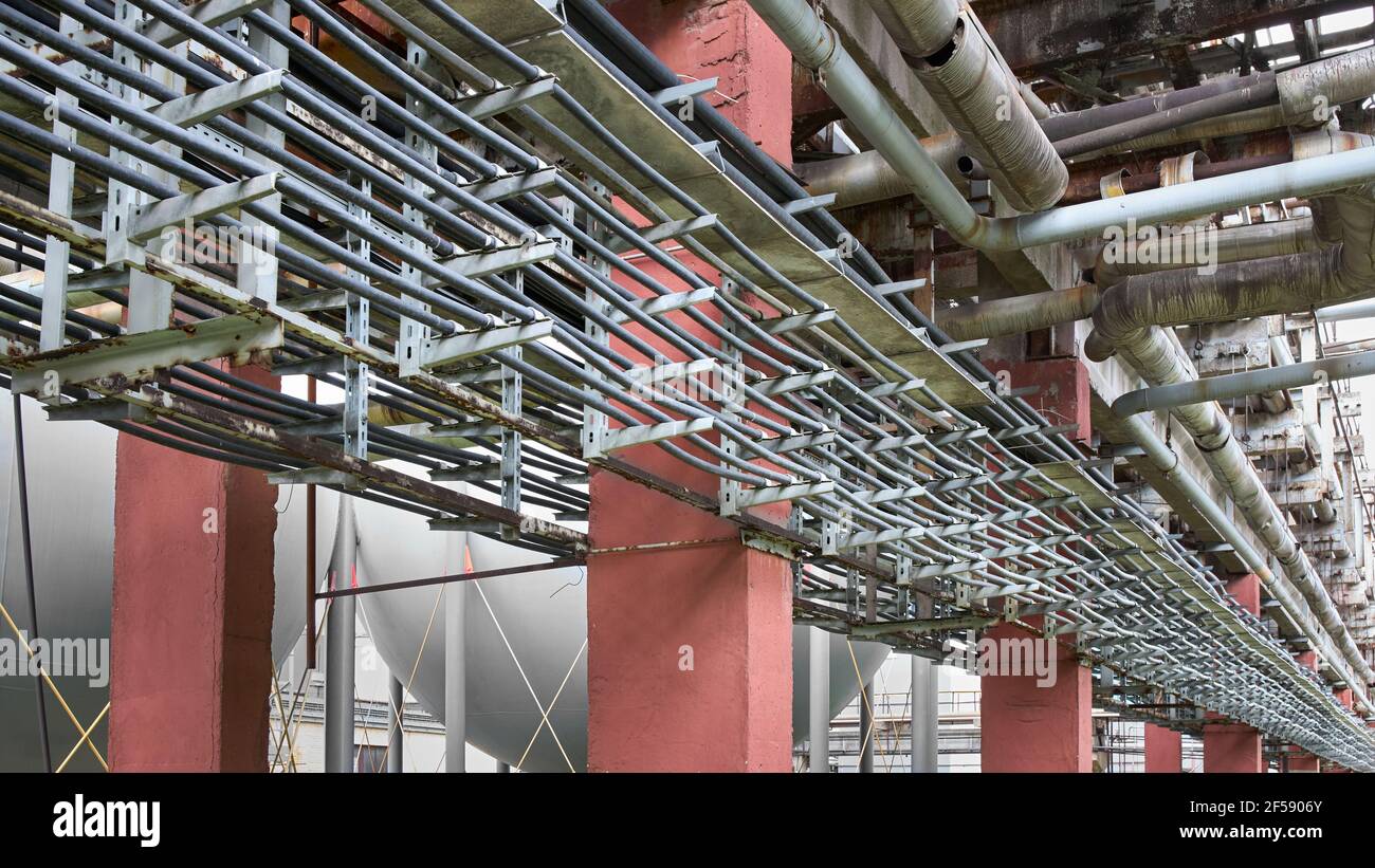 Kabelführung auf Stahlstützen. Reihen paralleler Stromkabel, die für die  Stromversorgung von petrochemischen Produktionsanlagen verlegt sind.  Industrie Stockfotografie - Alamy