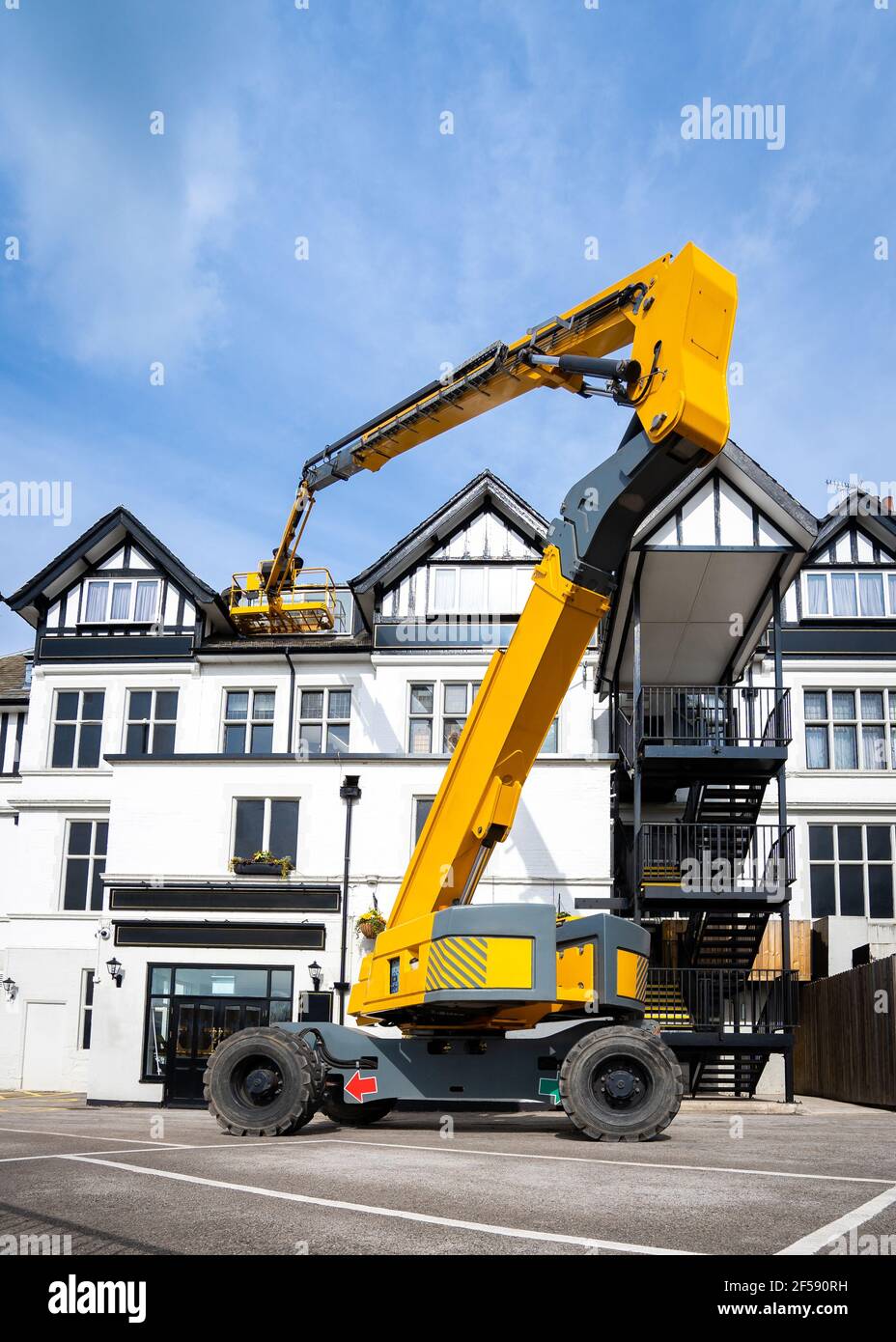 Gelber hydraulischer Auslegerarm für erhöhte Arbeitsbühne, ausgefahren, um in der Höhe der Hubarbeitsbühne zu arbeiten. Cherry Picker ausgefahren hoch in Luft Reparaturen angehoben Stockfoto