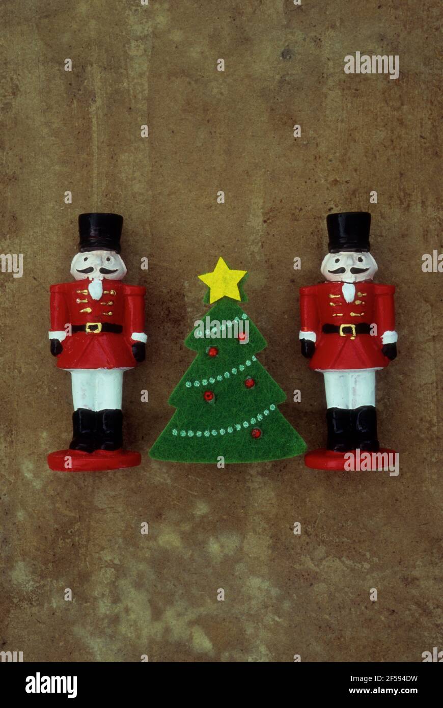 Modelle von zwei Soldaten des 19. Jahrhunderts in roten Jacken und Schnurrbärte stehen auf beiden Seiten des Weihnachtsbaums Stockfoto
