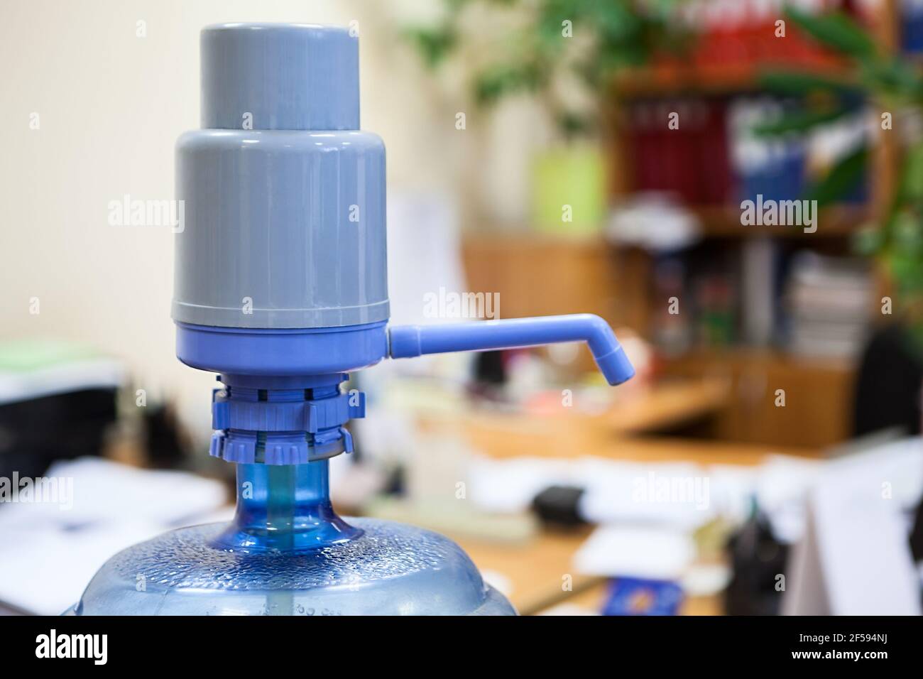 Große Plastikflasche mit blauem Pumpenspender im Büro, Copyspace Stockfoto