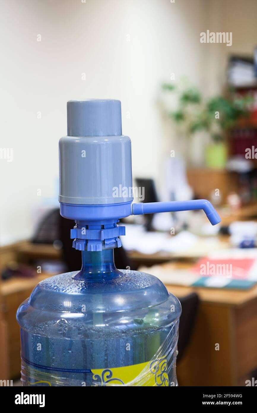 Große Plastikflasche mit blauem Pumpenspender im Büro Stockfoto