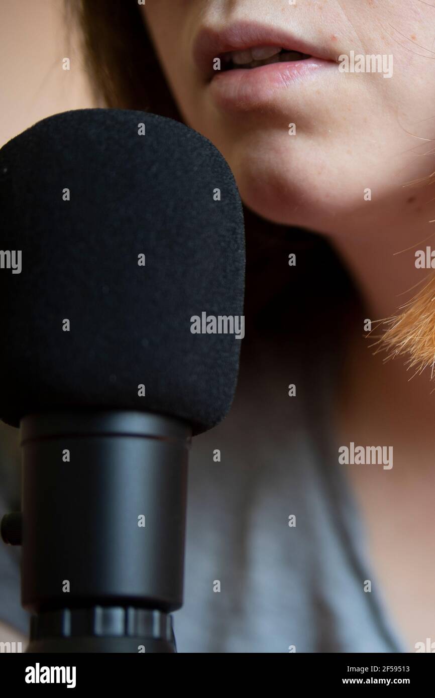 Weiße kaukasische junge Frau tun einen Podcast vor Ein Mikrofon Stockfoto