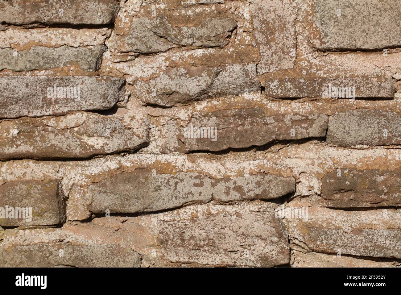 Steinmauer Muster aus Sandstein mit Mörtel zwischen rauem Stein Formen Stockfoto