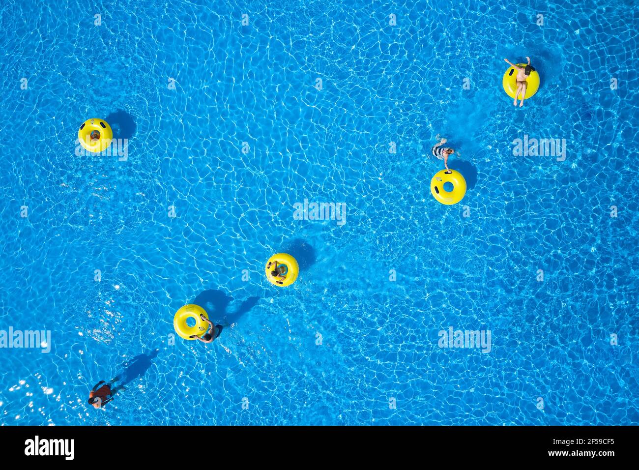 Wasserpark im Hintergrund. Draufsicht - Jugendliche entspannen sich im Swimmingpool im Schaumbad. Stockfoto