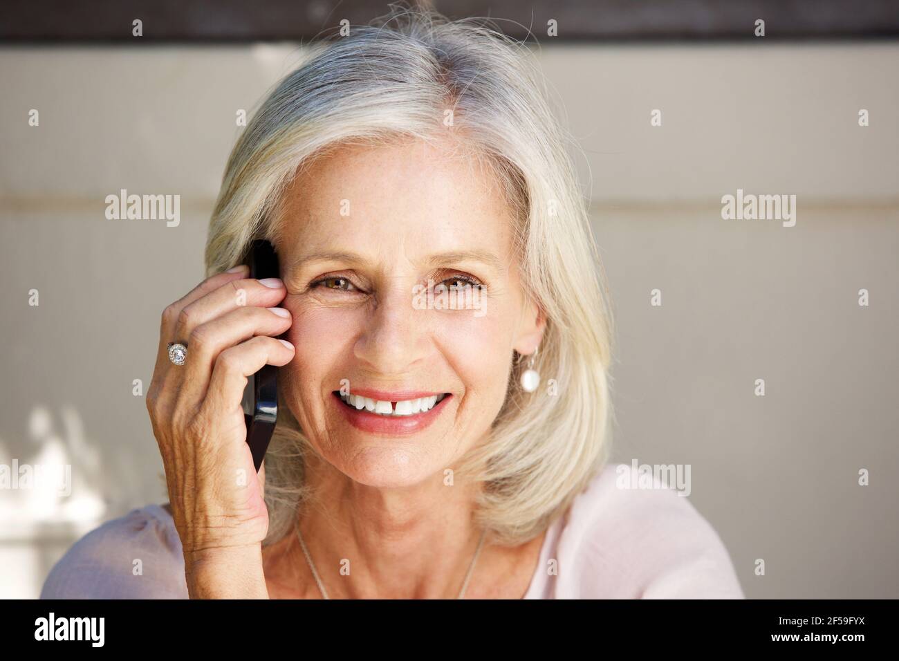 Nahaufnahme Porträt der schönen älteren Frau im Gespräch auf Zelle Telefon draußen Stockfoto