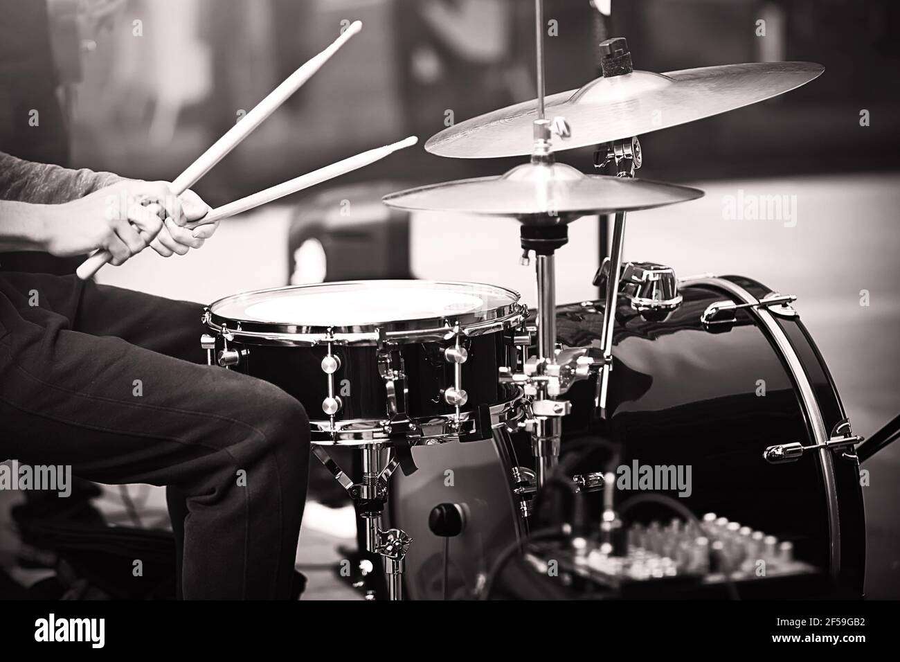 Ein Schwarz-Weiß-Bild eines Musikers, der mit Holzstöcken bei einem Songfest-Auftritt Schlagzeug spielt. Musik und Kreativität. Stockfoto