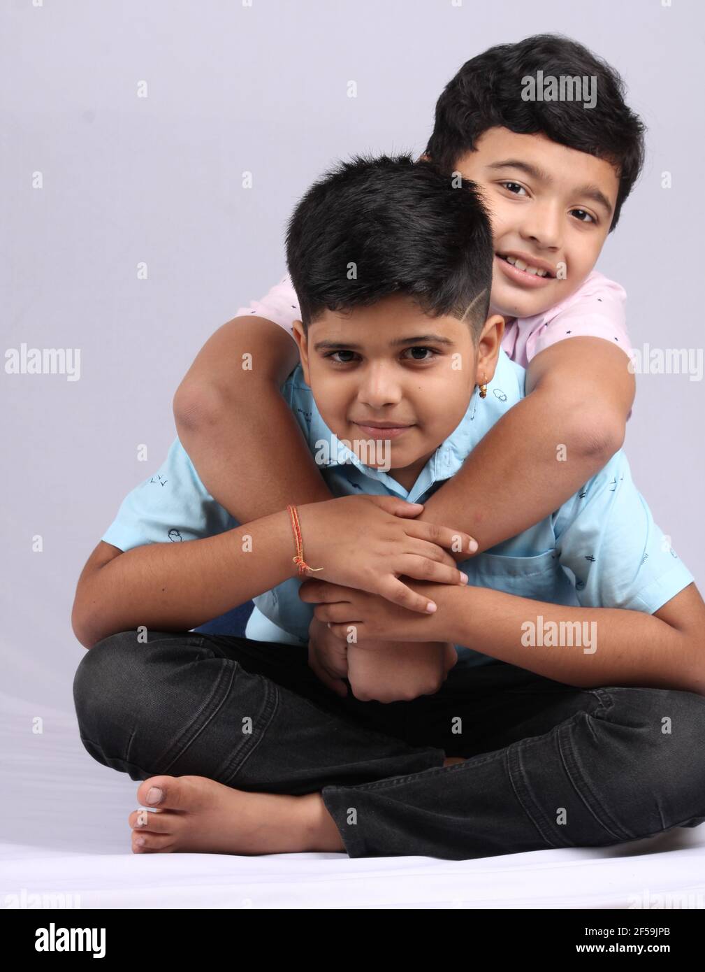Fröhliche indische Geschwister umarmen und posieren für ein Foto. Stockfoto