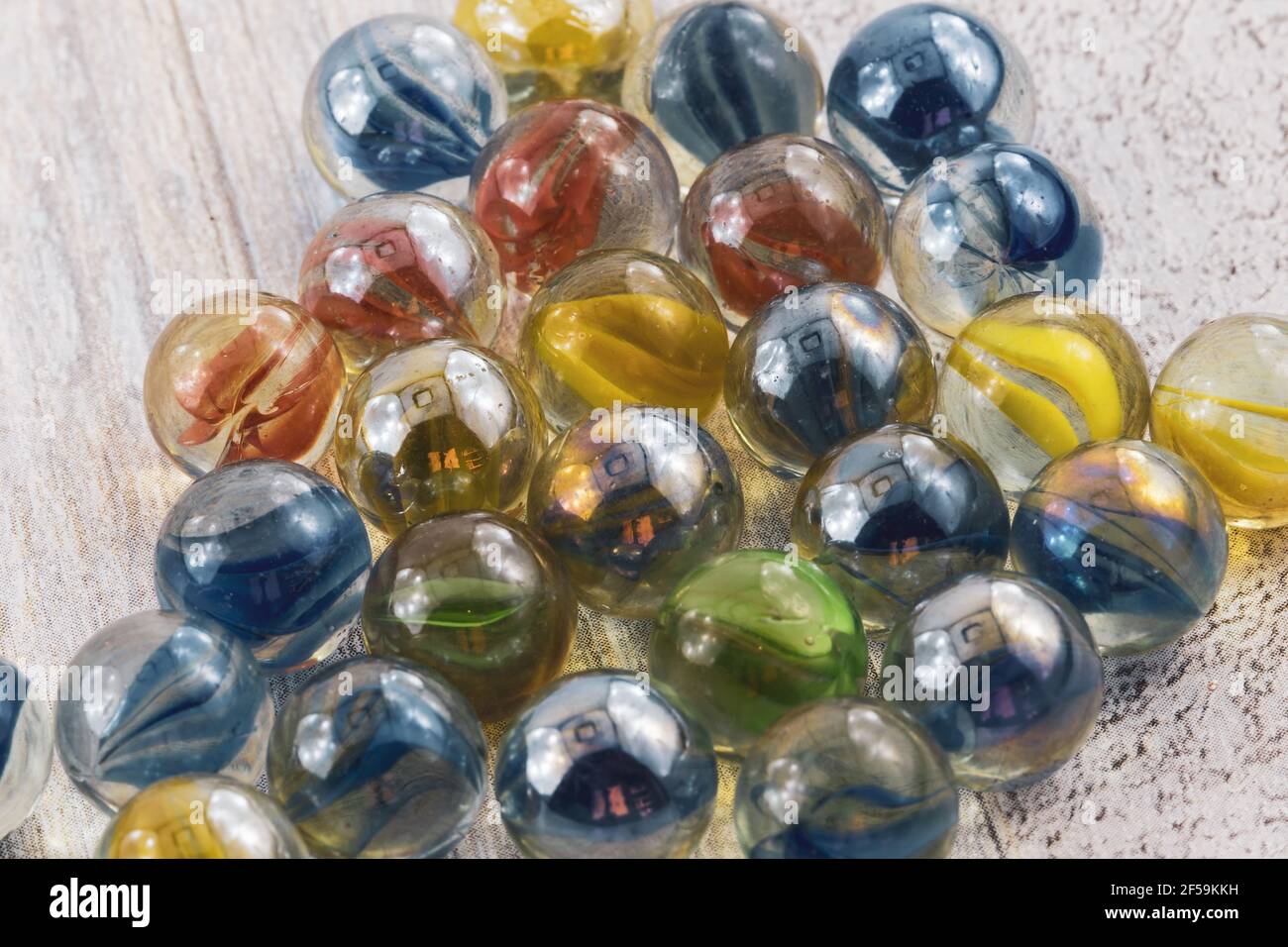 Rote, gelbe, grüne und blaue Glasmarmore auf einer Holzfläche Stockfoto
