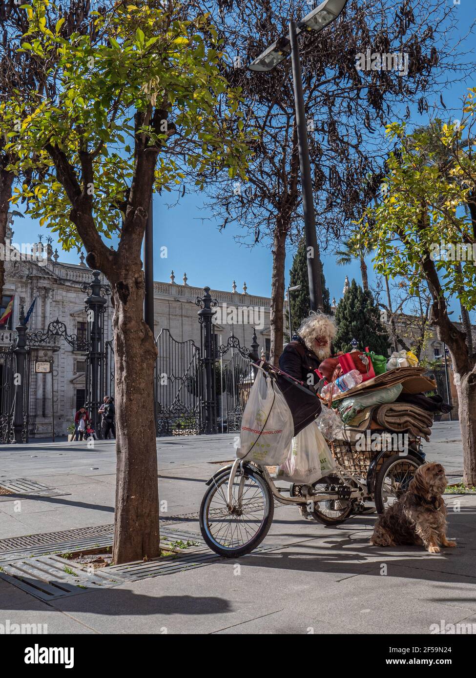 Ein Obdachloser und sein Hundegefährte mit Fahrrad und Habseligkeiten in Sevilla Spanien Stockfoto
