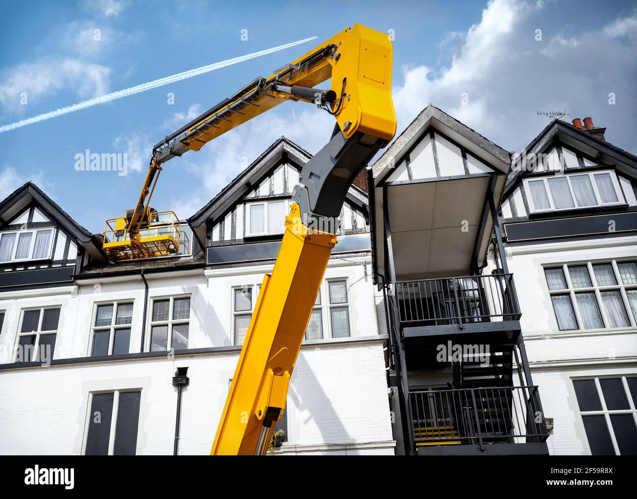 Gelber hydraulischer Auslegerarm für erhöhte Arbeitsbühne, ausgefahren, um in der Höhe der Hubarbeitsbühne zu arbeiten. Cherry Picker ausgefahren hoch in Luft Reparaturen angehoben Stockfoto
