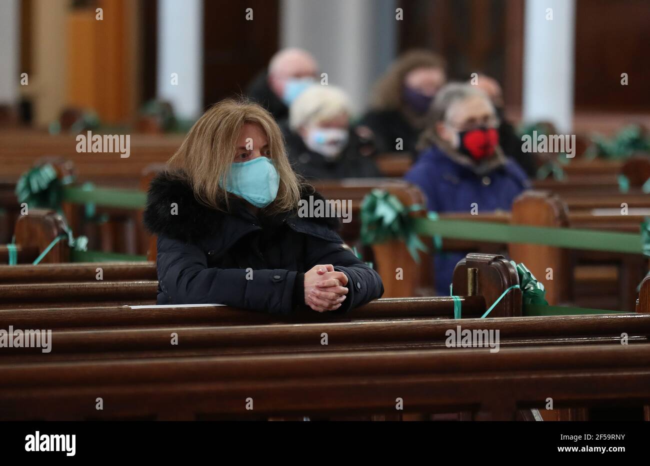 Ein Gemeindemitglied sitzt als Canon Tom White hält einen Massendienst in St. Mary's Catholic Chuch in Calton, Glasgow, nachdem Coronavirus-Vorschriften, die die Schließung von Kirchen in Schottland und kriminalisierte öffentlichen Gottesdienst wurden als rechtswidrig vom Court of Session. Kirchen sollen am Freitag unter Anleitung der schottischen Regierung geöffnet werden. Bilddatum: Donnerstag, 25. März 2021. Stockfoto