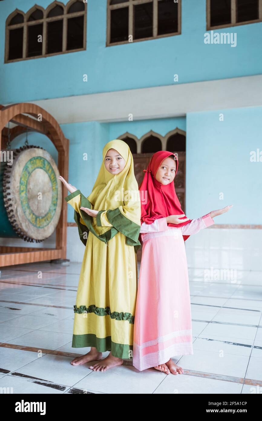 Zwei Kind Mädchen asiatische Muslim lächelnd zeigt etwas Stockfoto
