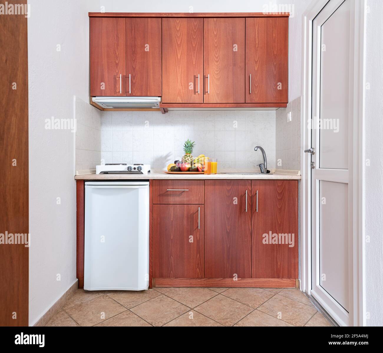 Vorderansicht von hölzernen Küchenschrank Modul Schrank mit kleinem Kühlschrank und Obstteller, Classic Stil Interieur weißen Studio-Zimmer mit natürlichen Eichenfell Stockfoto