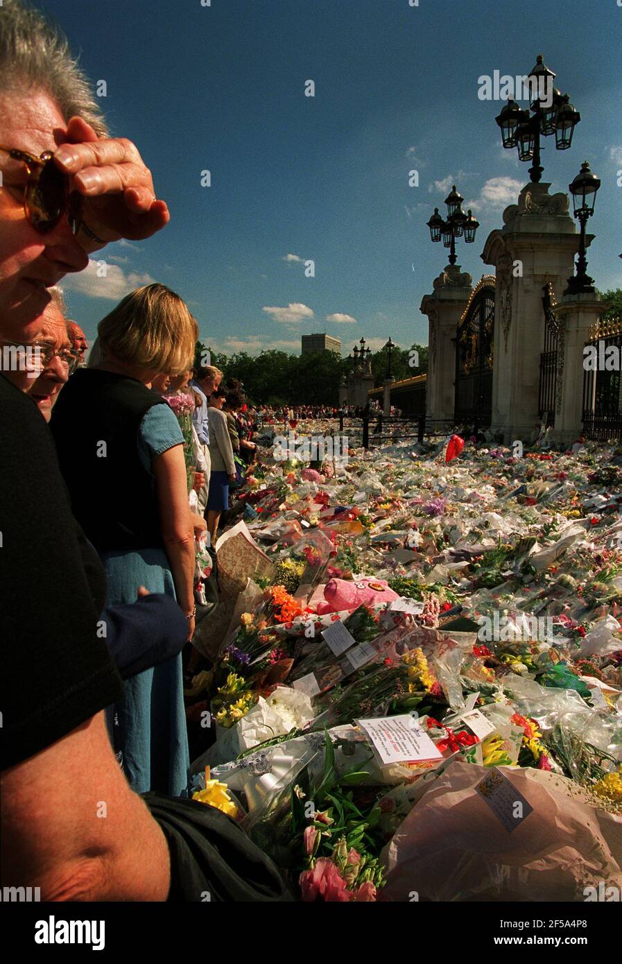 Prinzessin Diana Tod 31. August 1997Mourners Blumen legen und betrachten Links vor dem Buckingham Palace in Erinnerung an Prinzessin Diana, die Wurde bei einem Autounfall in Paris getötet Stockfoto