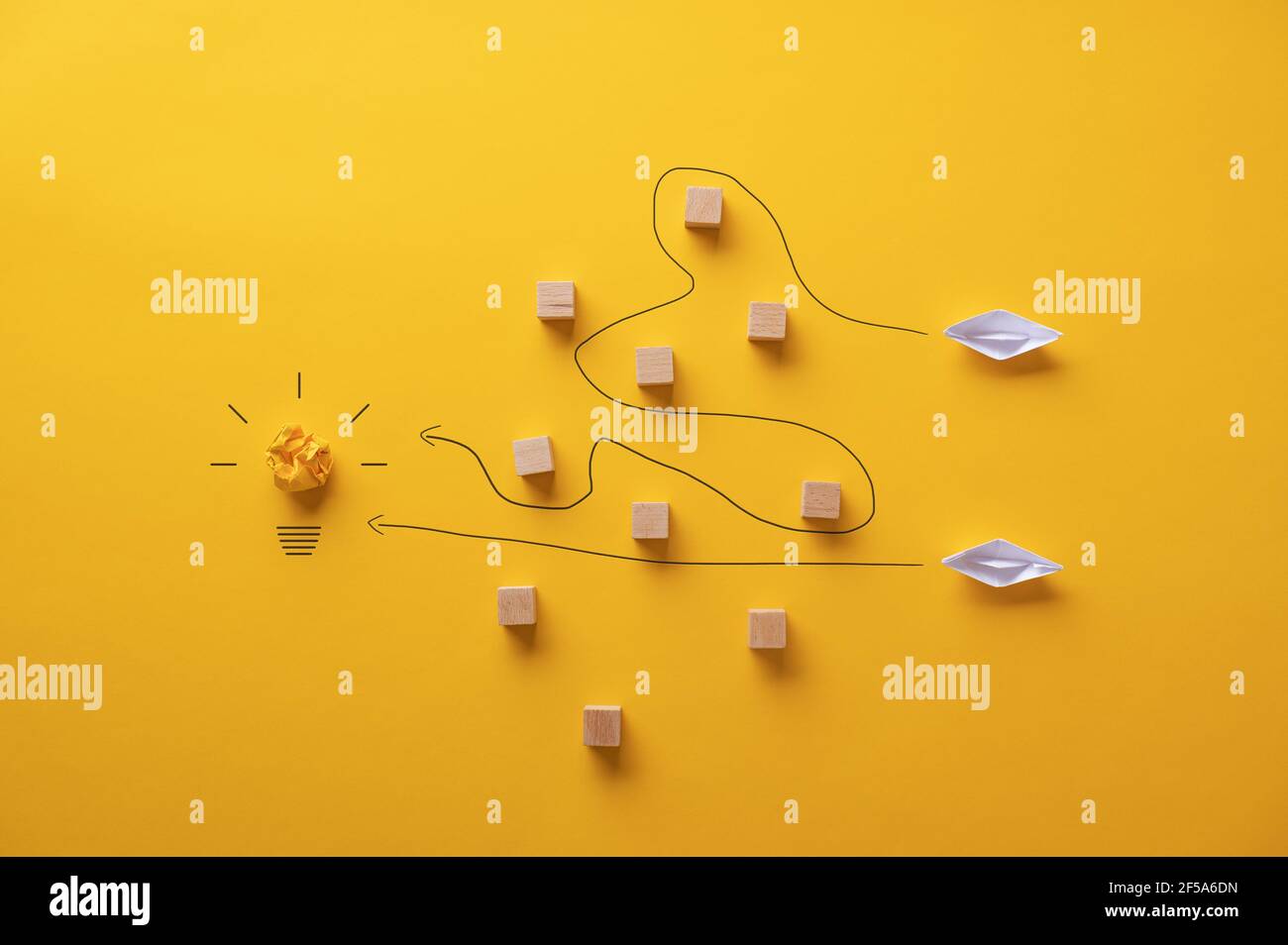 Zwei Papier Origami gemacht Boote versuchen, ihre Ziele und Ambitionen durch Reisen verschiedene Wege zu erreichen. Stockfoto