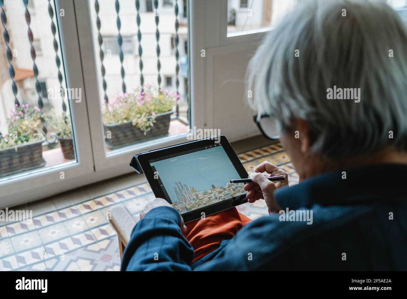 Alter Mann, der mit einer Tablette zeichnet Stockfoto