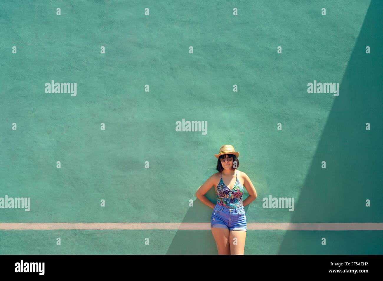 Porträt einer hübschen jungen Frau vor einem Training Wand auf einem Tennis Stockfoto