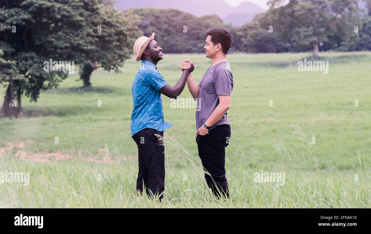 Konzept der besten Freunde, afrikanischen Mann und asiatischen Mann Handshake mit Lächeln und glücklich Stockfoto