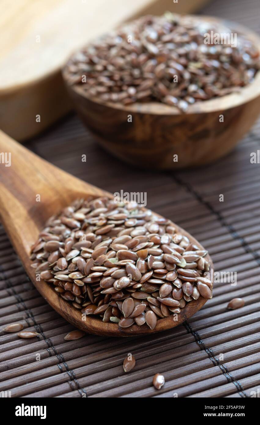 Gesundes Ernährungsprodukt, Leinsamen auf einem Löffel auf einem Holztisch Stockfoto