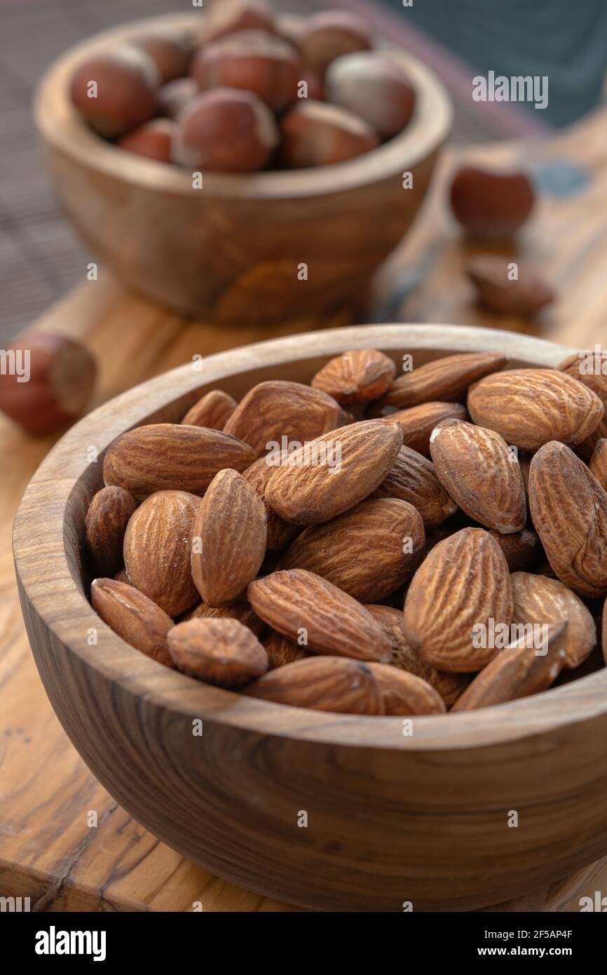 Snack Food Konzept, Nüsse in Holzteller auf dem Tisch Stockfoto