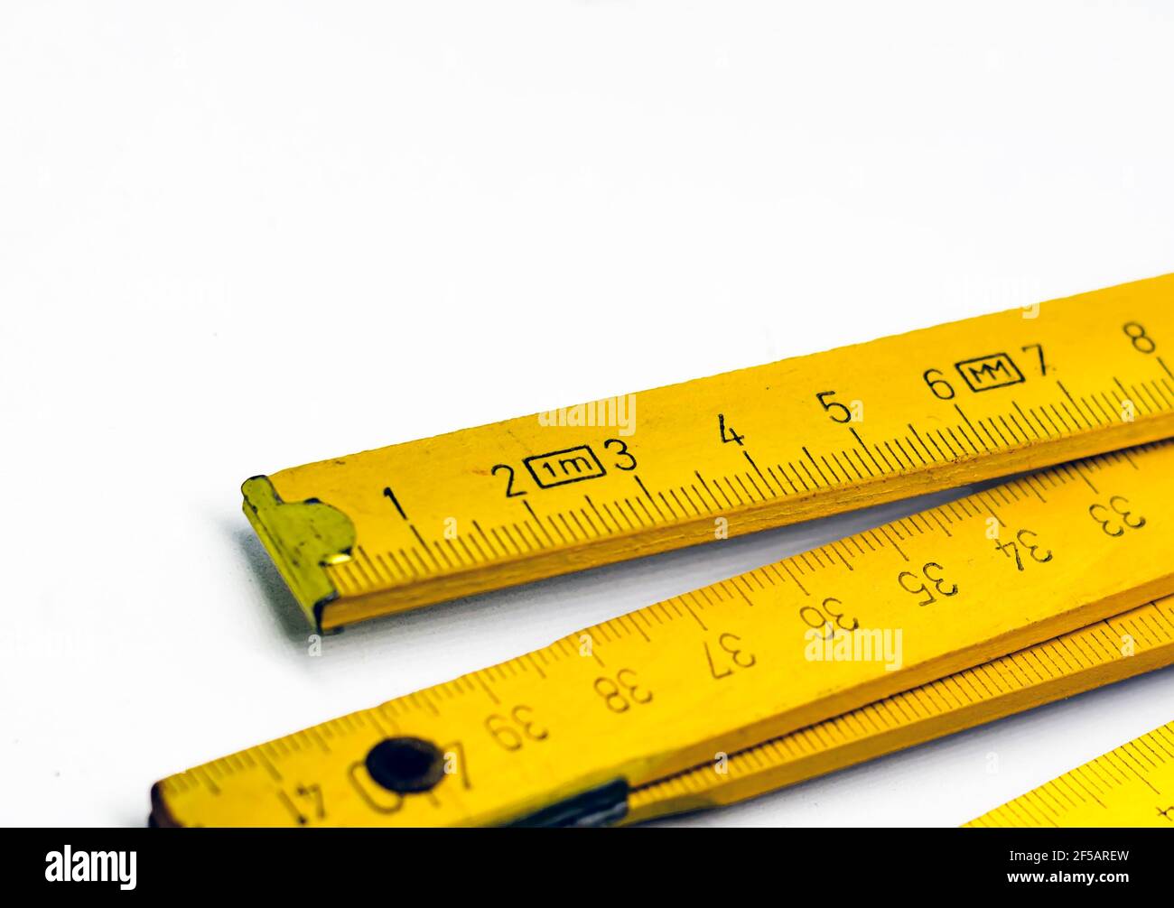 Detail eines klappbaren Holzmeters. Messwerkzeug für Bau- und Renovierungsarbeiten. Graduierte Skala in Zentimetern. Stockfoto