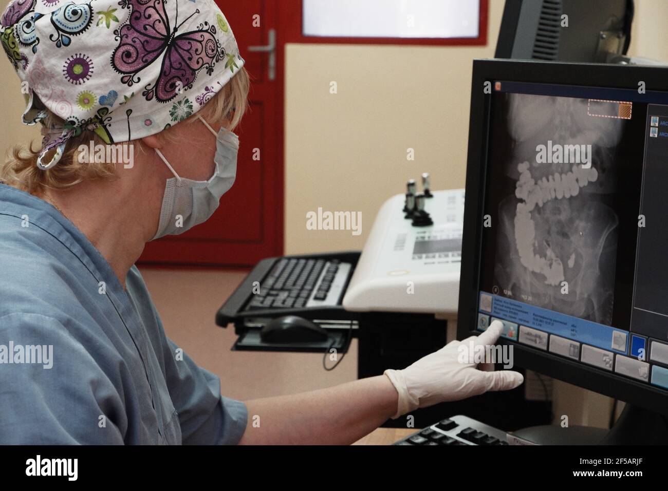 Eine Radiologin hinter dem Monitor führt eine Röntgenkorrektur durch Stockfoto