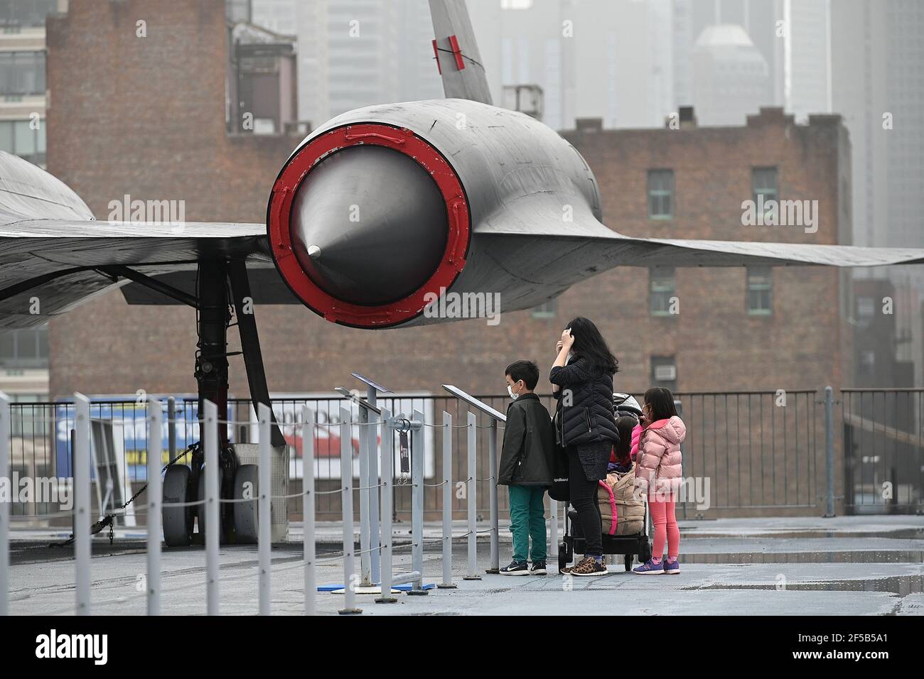 New York, USA. März 2021, 25th. Besucher sehen sich ein Lockheed A-12 CIA-Aufklärungsflugzeug an, das auf dem Flugdeck des Intrepid Sea, Air & Space Museums ausgestellt ist und heute nach einem Jahr wegen der COVID-19-Pandemie für die Öffentlichkeit wieder geöffnet ist, New York, NY, 25. März 2021. Das schwimmende Museum, das an Manhattans West Side angedockt ist, wird die Kapazität auf 25% begrenzen, den Eintritt zeitlich eingrenzen und Gesichtsbedeckung und soziale Distanzierung erfordern. (Foto von Anthony Behar/Sipa USA) Quelle: SIPA USA/Alamy Live News Stockfoto
