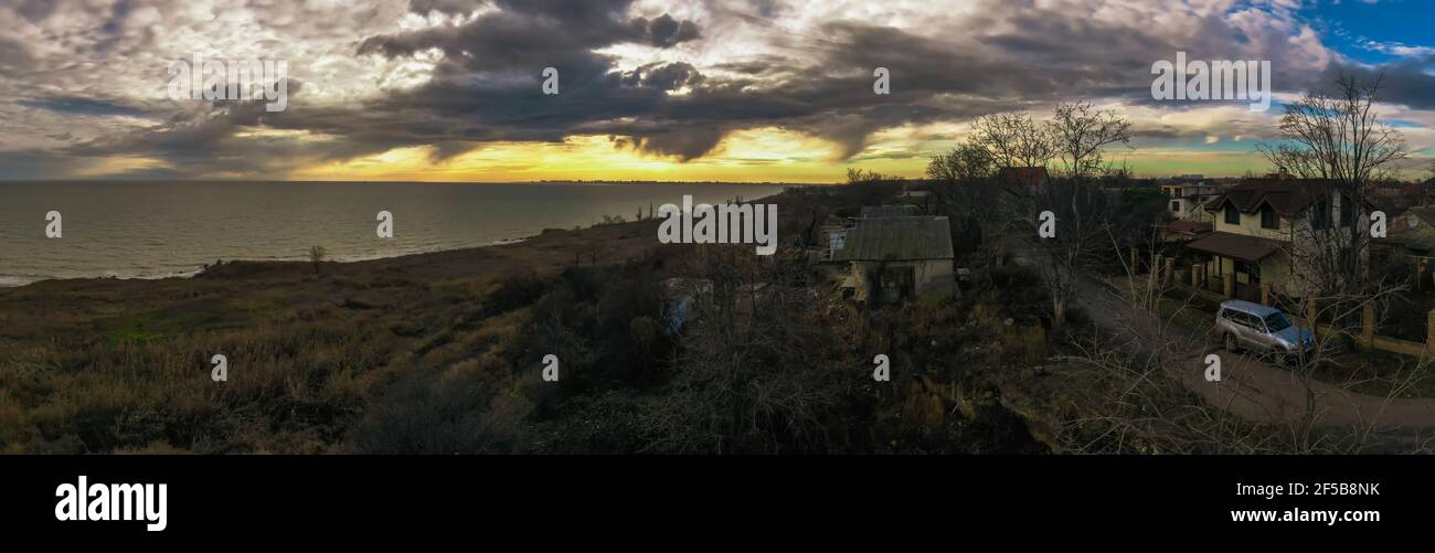 Sonnenuntergang über dem Meer. Schönes Panorama mit langbelichteten Landschaften und Dorfruinen. Vintage-Foto von Fontanka Odessa Ukraine. Stockfoto