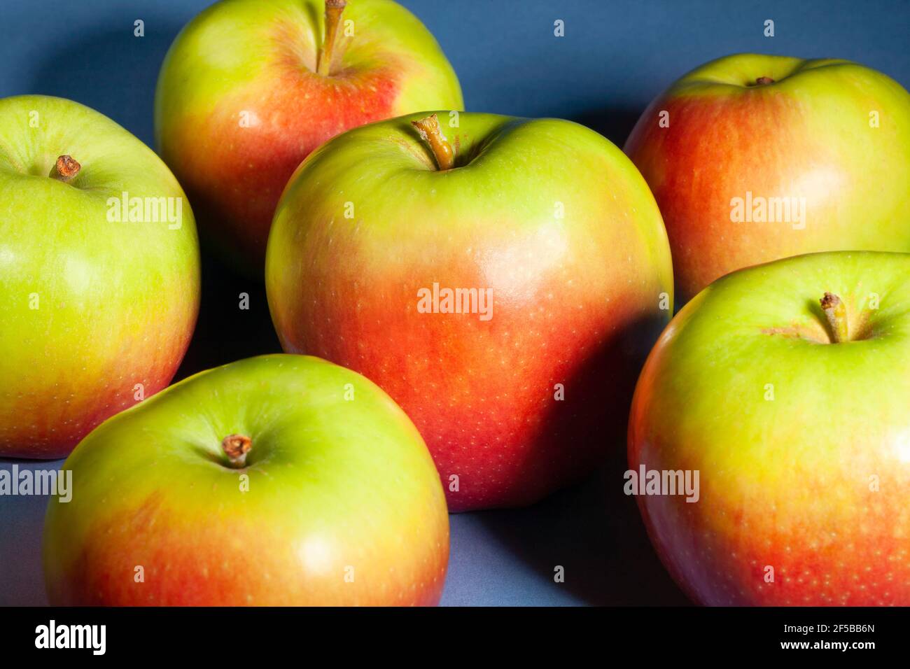 Rot grüner Apfel auf blauem Hintergrund Stockfoto